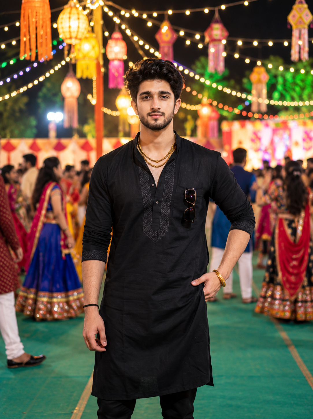 Indian man wearing a black traditional kurta at a decorated Garba venue at night
Copy alt text